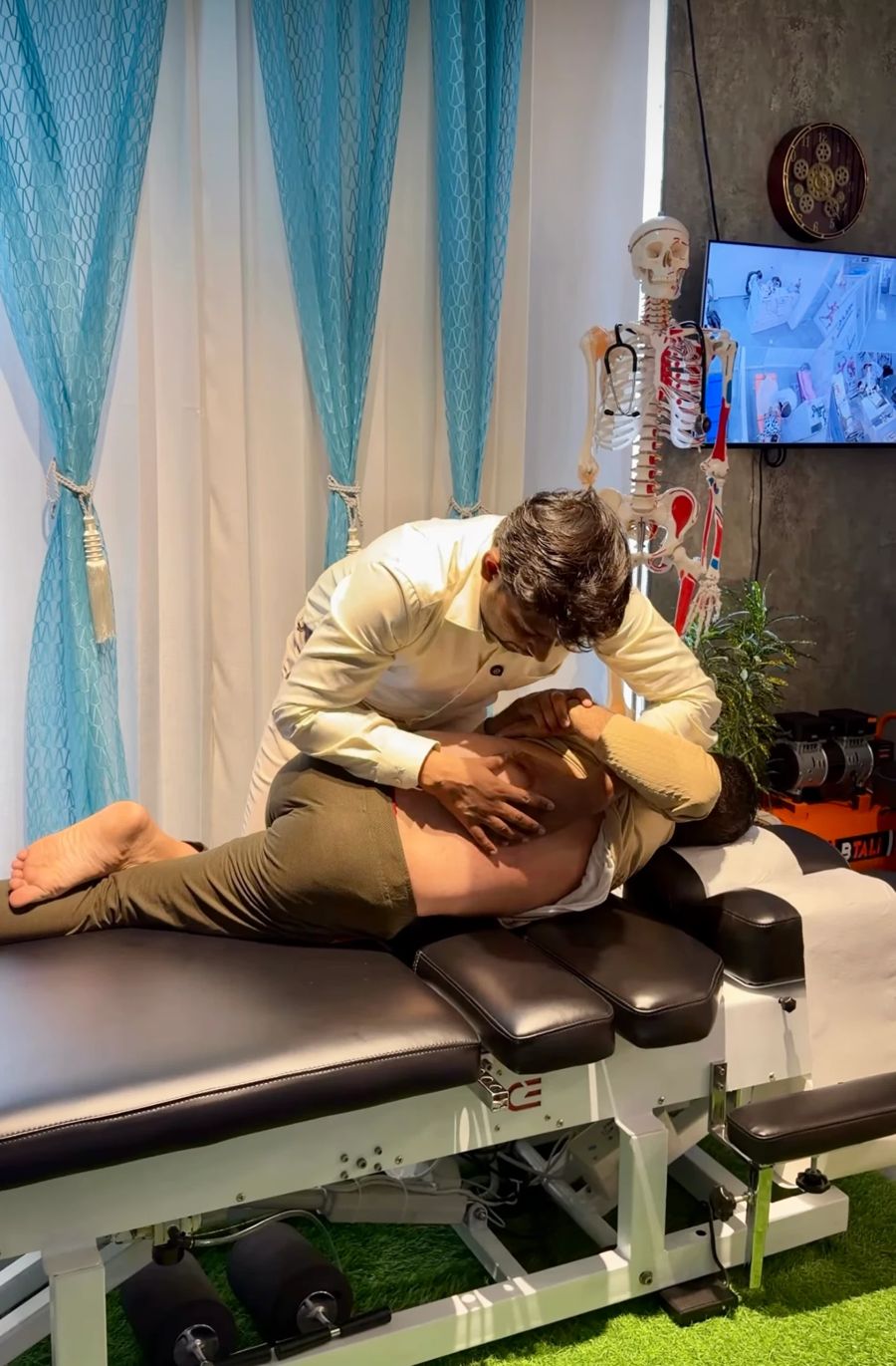 Dr. Kailash performing a lower back manipulation on a patient lying on a chiropractic table in Dehradun